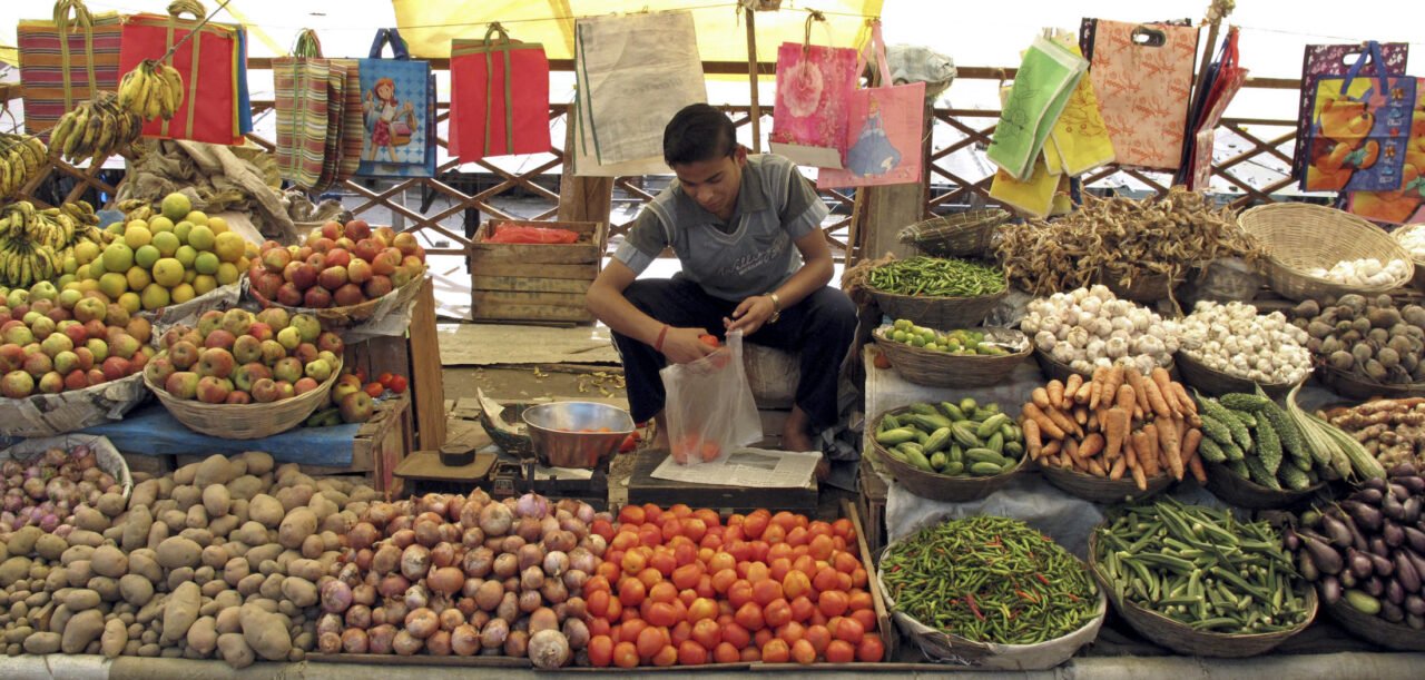 A vendor waits for customers at a vegetable market in Rabangla town