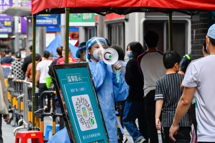 A volunteer in protective gear guides citizens at a nucleic acid testing site in Luohu District of Shenzhen, south China’s Guangdong Province, March 13, 2022. (Photo by Chu Yan/Xinhua/IANS)