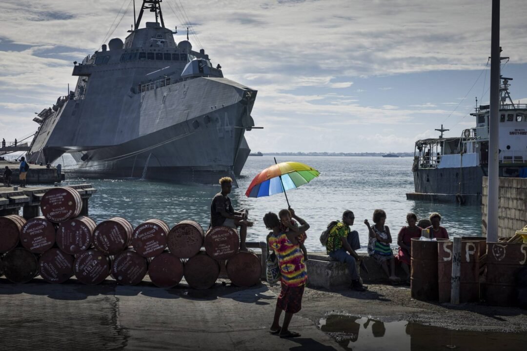 U.S. combat ship Oakland stationed by the harbor in Honiara, Solomon Islands, on Sunday, Aug. 7, 2022, where a crowd gathered to watch the memorial service. (Matthew Abbott/The New York Times)