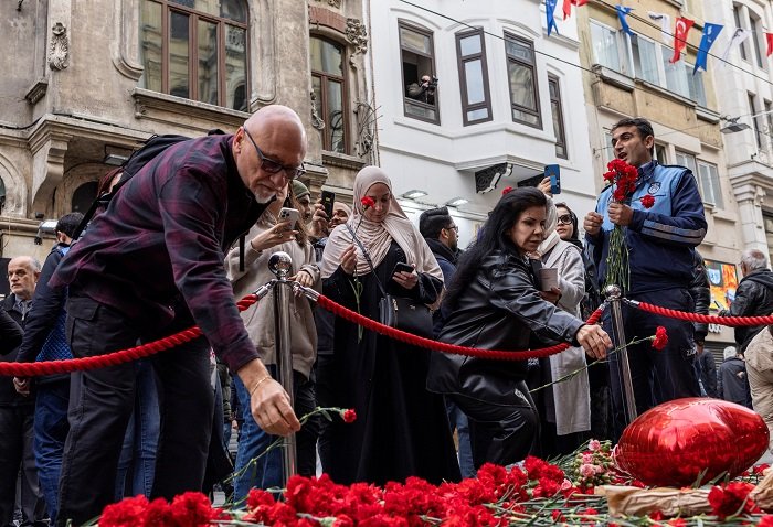 People lay flowers to pay tribute to the victims of a Sunday’s blast that took place on Istiklal Avenue in Istanbul