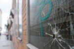 Bullet hole in a window with graffiti in an alleyway