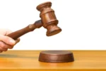 1829409-someones-hand-holding-wooden-law-gavel1